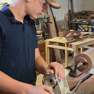 A 4-H member turns wood on a lathe